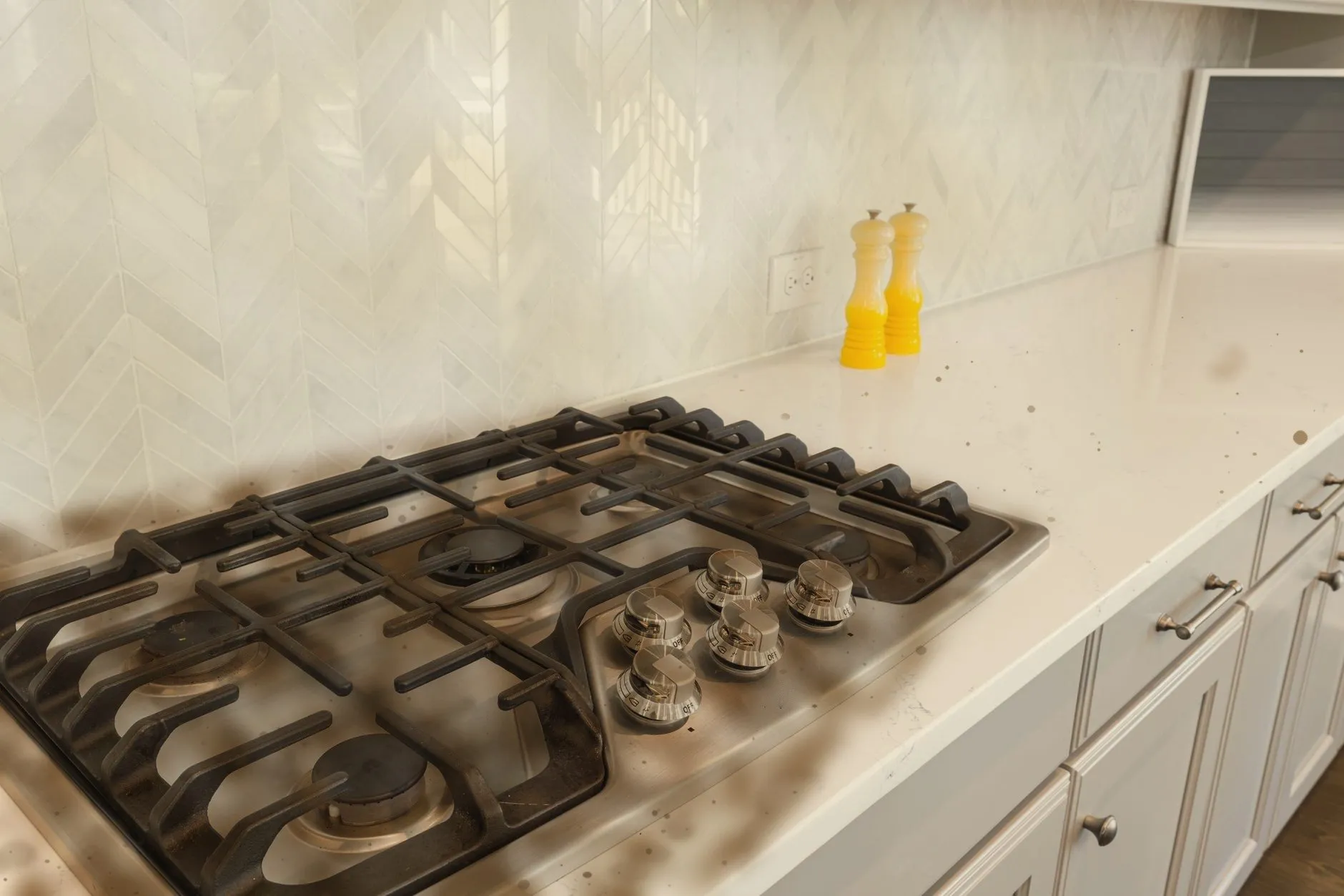 A gas hob and worktop with grease, burnt rings and crumbs before a deep clean