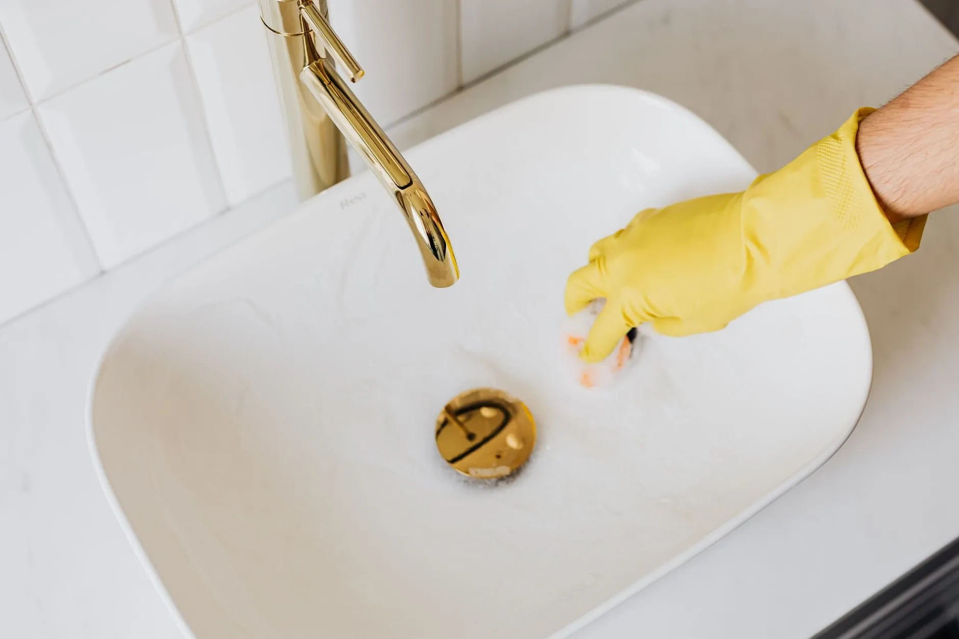 The same white basin and brass tap wiped clean